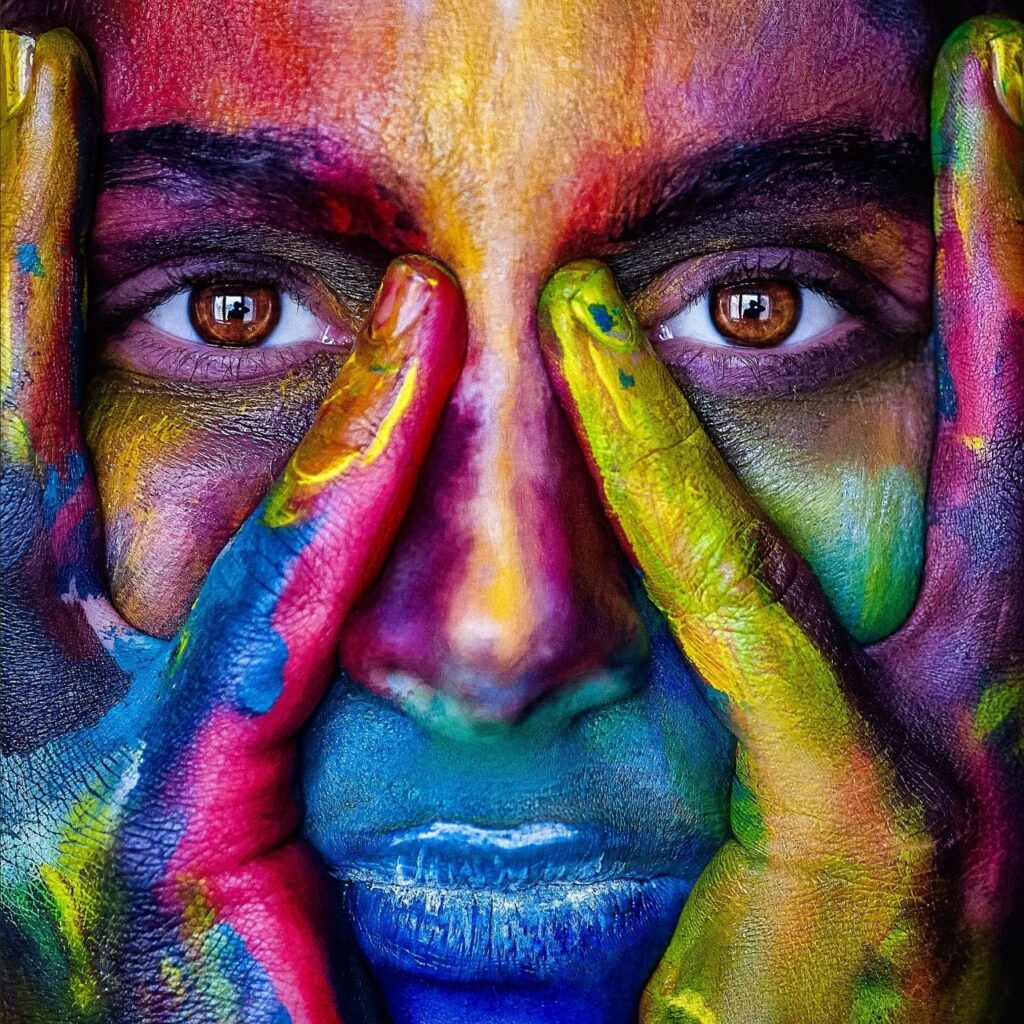 Person med målarfärg håller händerna på ansiktet